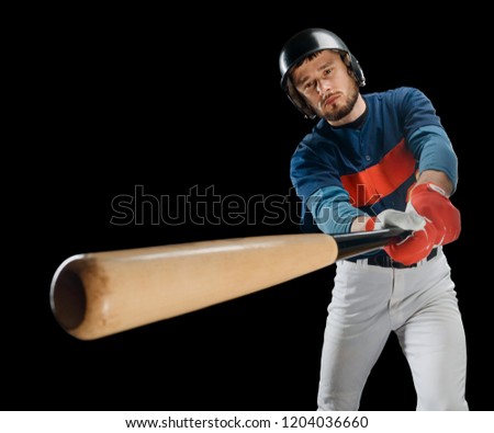 Young man playing baseball. A huge wooden bat in player's hands and narrow look. Sport background with copy space.