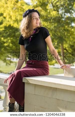 The girl in beret and skirt in the park