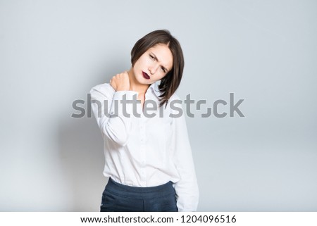 Closeup of business woman with neck pain, short hair cutting, isolated over gray background