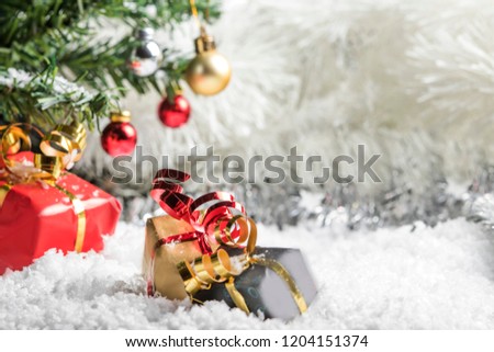 Presents lying in the fake snow under the Christmas  tree