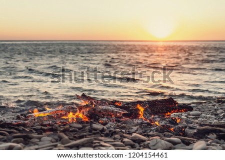 burning fire at sunset in the background of the sea