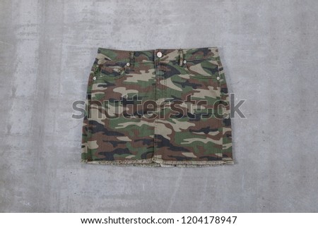 Skirt with camouflage pattern on gray background 
