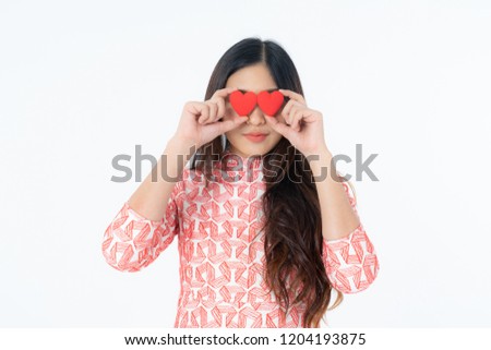 Photo of asian curious woman in red dress rejoicing her birthday or new year. Young woman holding red heart being excited and surprised  holiday present isolated white background