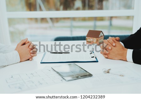 Close-up. Contract Signing Concept. Property Buy. Bright Office. Business Meeting. Customer And Buyer. Offer Discussion. Professional Agreement. House Selling Proposal. Document Signature.