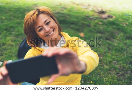 tourist girl on background green grass taking photo selfie on mobile smart phone, person looking on camera gadget technology, blogger using content online wifi internet lifestyle concept