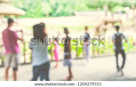 Abstract blurred image of  people looking to Giraffe at  safari zoo with bokeh for background usage . (vintage tone)