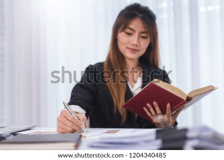 Business young women reading book at workplace in office. Knowledge and education concept