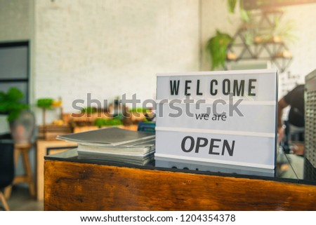 Small business owner putting welcome Signs. Welcome Signs letters printed on white board putting guests at the shop.