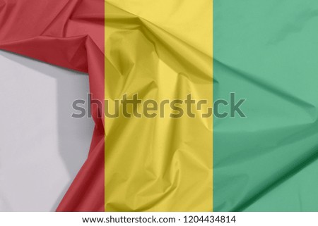 Guinea Bissau fabric flag crepe and crease with white space, vertical red line with black star two horizontal yellow and green.
