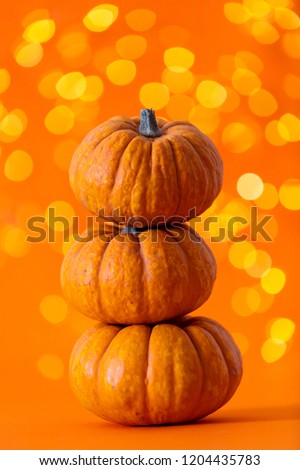 Halloween pumpkins against bright orange blurred lights background