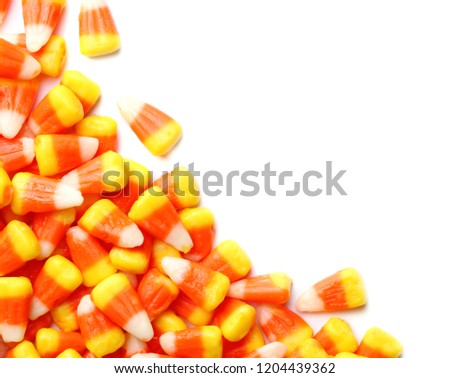 Colorful candy corns for Halloween party on white background, top view