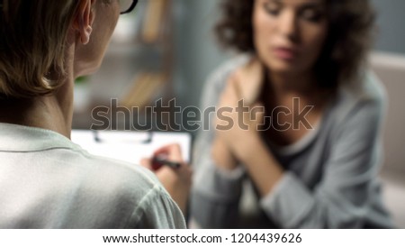 Female psychologist listening to young lady during personal session, depression Royalty-Free Stock Photo #1204439626