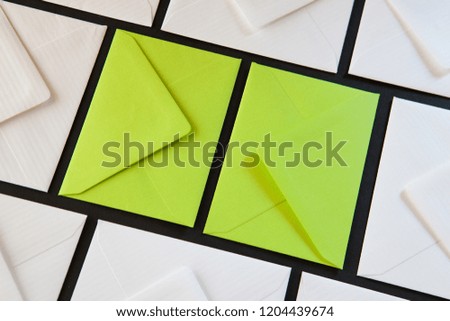 Composition with white and green envelopes on the table. Different colored envelopes on the table.