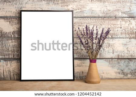 Mock up of an empty frame poster on a wall of wooden boards. A bunch of lavender in a vase  