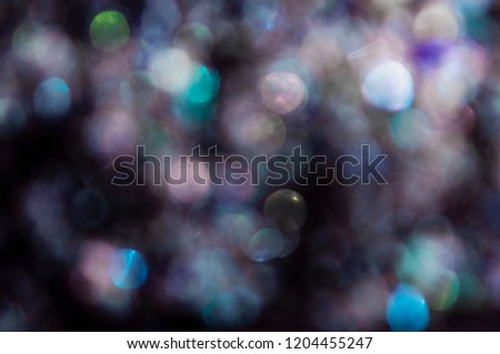 Middle size bokeh lights on a dark background. Perfect for christmas or new year party invitation or as festive background, 