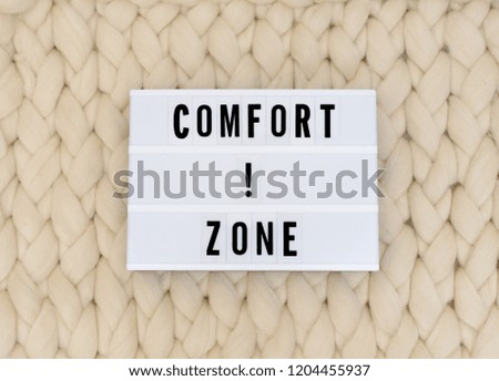 COMFORT ZONE word on lightbox on knit background. COMFORT ZONE concept. 