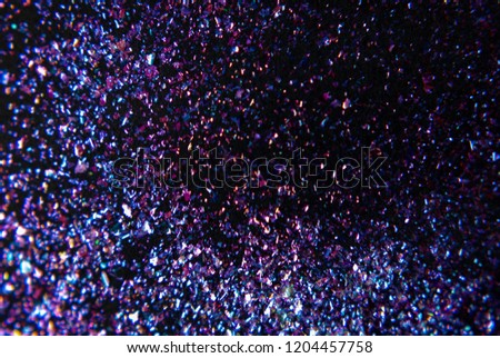Glitter flat lay on a dark background. Bright magic effect. Starry night sky concept. Perfect for festive invitation, party, christmas wallpaper or greeting card.