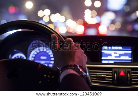 hands on wheel and city nightlife Royalty-Free Stock Photo #120451069