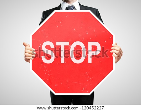 businessman holding a stop sign