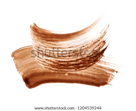 Smear of brown mascara for eyelashes isolated on white background.