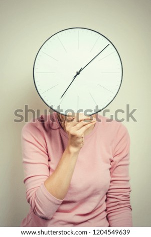 Girl covering her face from clock. Woman hides from stress and deadline concept