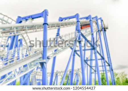 Defocused background of a rollercoaster inside an amusement park. Intentionally blurred post production for bokeh effect