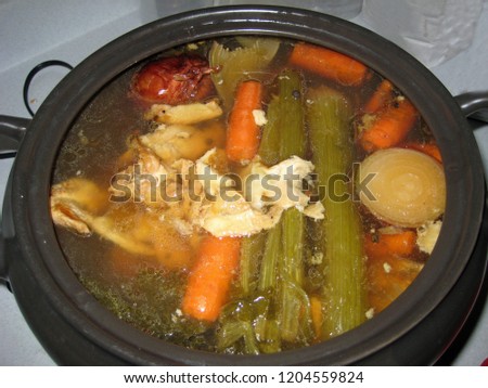 Vegetables and chicken parts for stock simmering in a slow cooker
