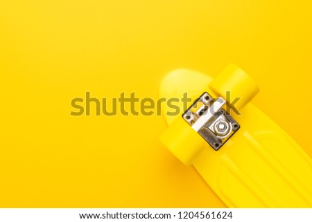 plastic mini cruiser board on yellow background. bright yellow cruiser skateboard with copy space