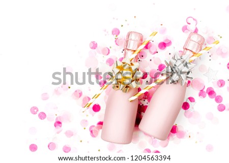 Pale Pink Mini bottles of champagne with confetti and tinsel. Flat lay. New year/Christmas celebration or wedding  concept theme. Flat lay, top view