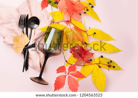 Festive table setting with Bright Autumn leaves on pastel background. Flat lay, top view, copy space