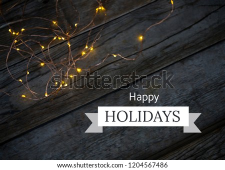 Digital composite of Happy holidays text with Christmas lights