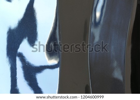 Black, shiny surface with reflections in blue and light blue, Berlin, Germany, October 2018 