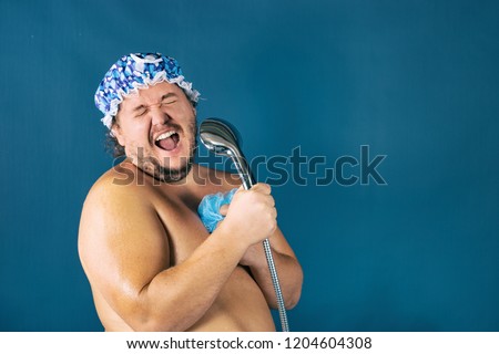 Funny fat man in blue cap sing in the shower. Fun and cleanliness Royalty-Free Stock Photo #1204604308