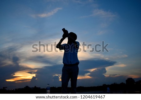 photographer posting on evening blue sky background