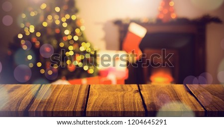 Digital composite of Christmas home with tree and stocking and wooden surface with bokeh lights