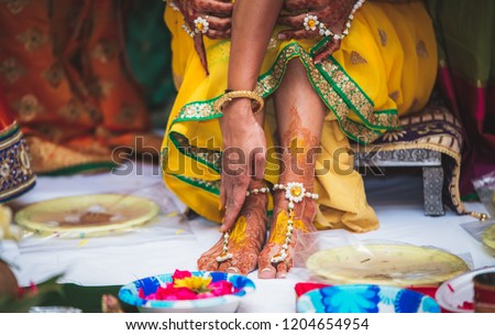 Indian Bridal ubtan haldi pasting for foot Mehndi ceremony Royalty-Free Stock Photo #1204654954