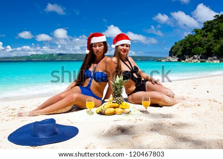 Two Woman celebrating Christmas on tropical beach