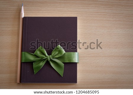 Book diary for gifts to give souvenirs and pencils placed on wooden table.