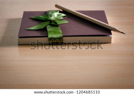 Book diary for gifts to give souvenirs and pencils placed on wooden table.