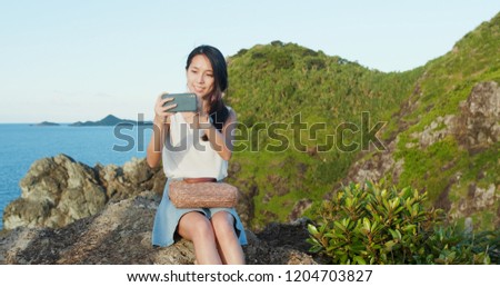 Woman take photo on cellphone in countryside