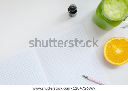 health wellness business planning photo with blank journal notebook essential oil orange green juice pen with white background social media image room for text or quote