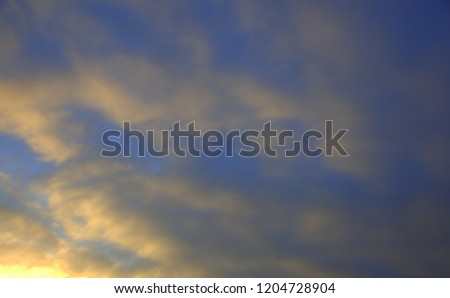 The sky, thunder clouds are illuminated from the rays of the rising sun. The picture was taken on an autumn morning.
