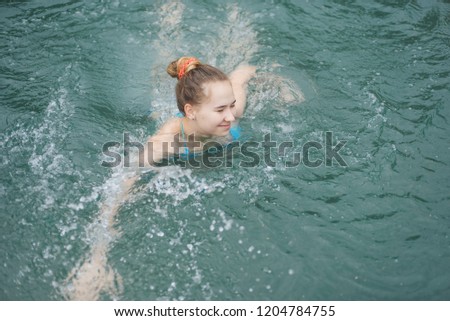 Happy day in water, girl swims, swim in the sea, water treatments. swim in front.