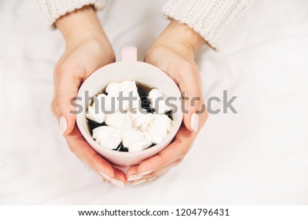 coffee with marshmallows in women's hands.top view.white background.