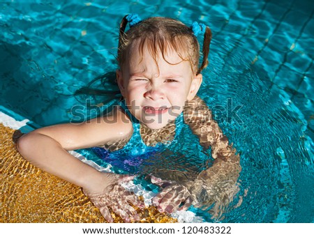 happy little girl splashing around in the pool