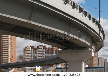 Geometry of the modern overpass. Sunny autumn day. View under the bridge