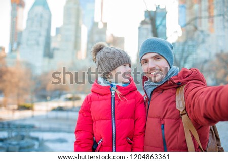 Family of father and little adorable girl taking selfie in Central Park at New York City