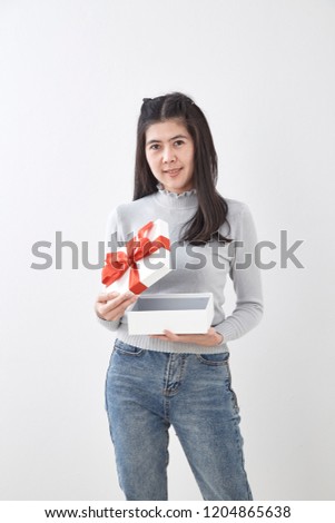 Portrait of beauty young woman with christmas gift on white wall background