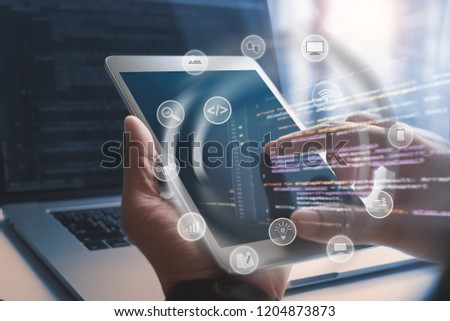 Software developer coding computer program with augmented reality dashboard, mobile app design with internet  icons on VR screen. Man hand using digital tablet, IoT Internet of Things concept