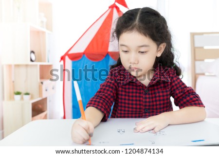 attractive Asian children leaning to use color pencil in her bedroom , art work time, felt tip pen
